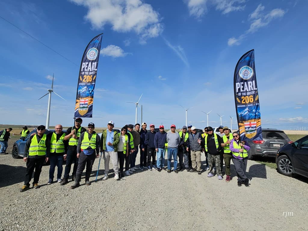 Volunteers from Pearl of the Orient Lodge No. 206 posing for a group photograph at the 2026 highway cleanup, standing between lodge banners.